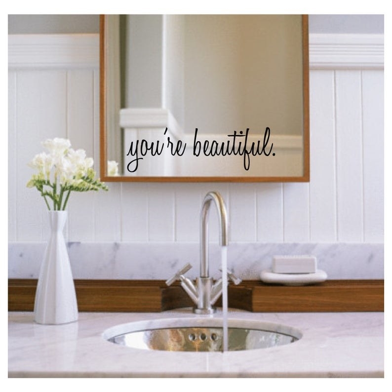 a mirror in the bathroom with the words &quot;you&#x27;re beautuful&quot; on it thanks to the decal