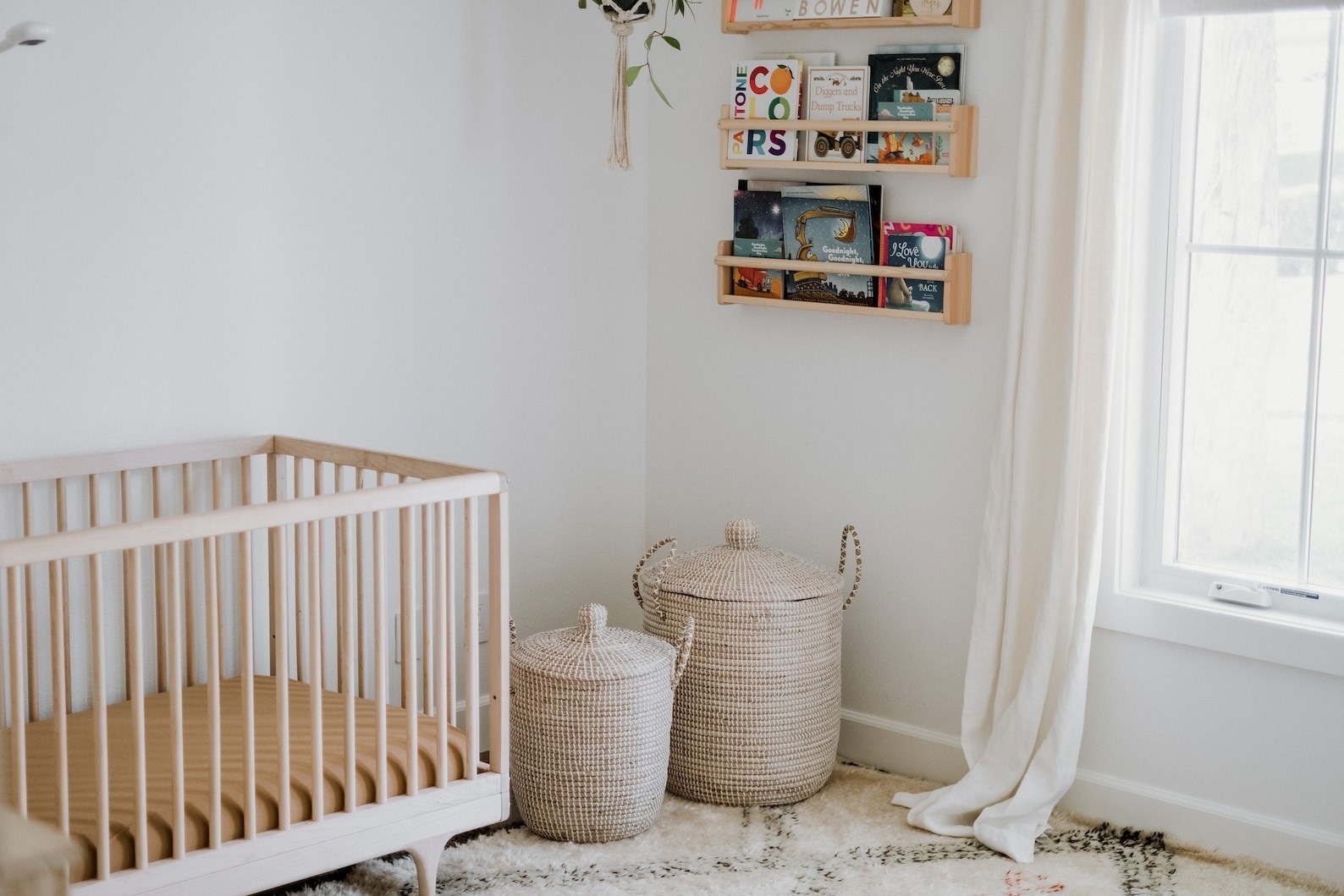 Two beige lidded wicker baskets in a nursery