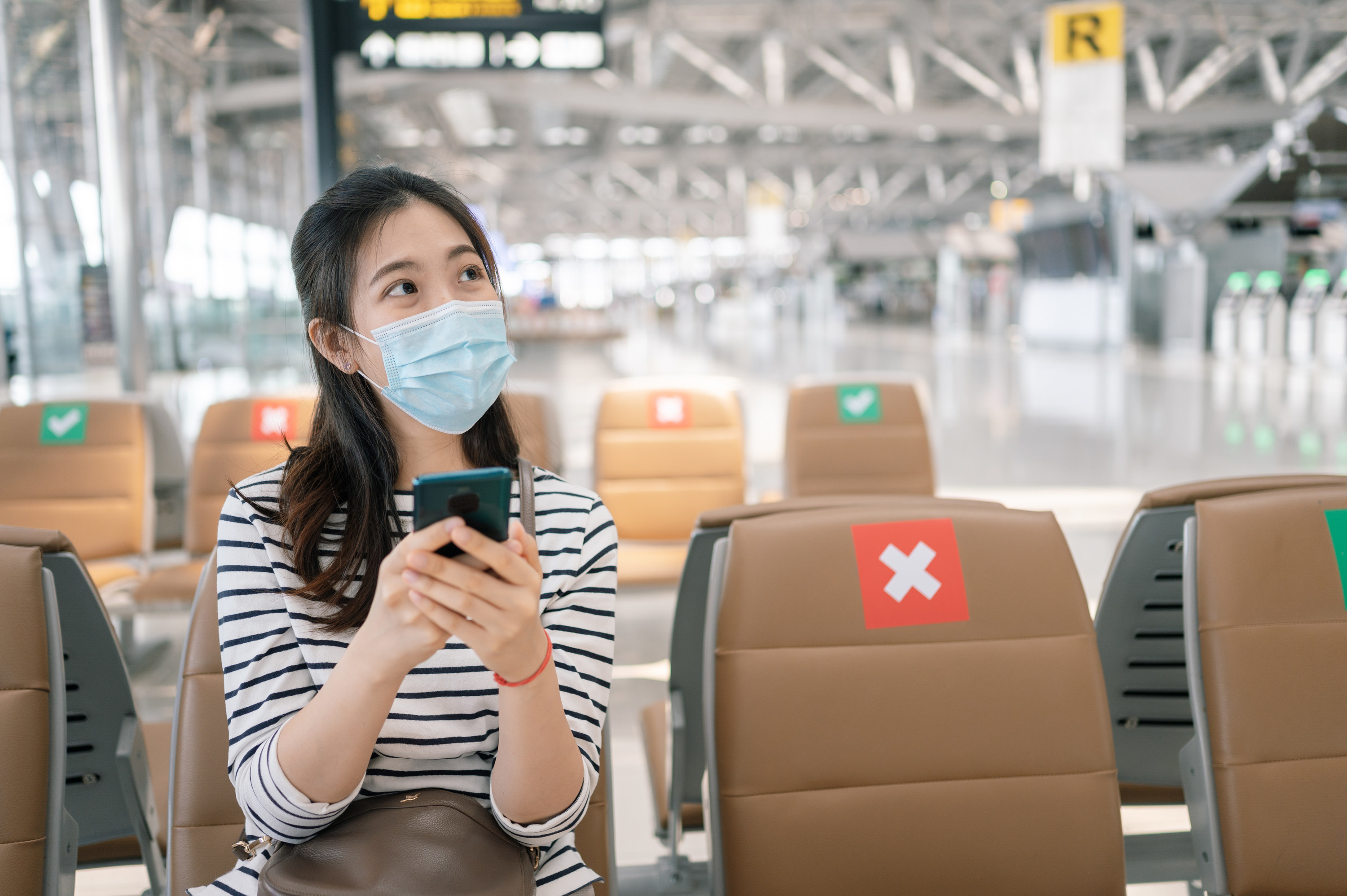 Woman in airport looking at her phone