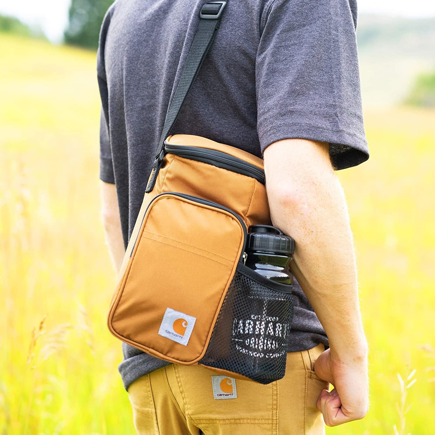 A person wearing the lunch bag in a field