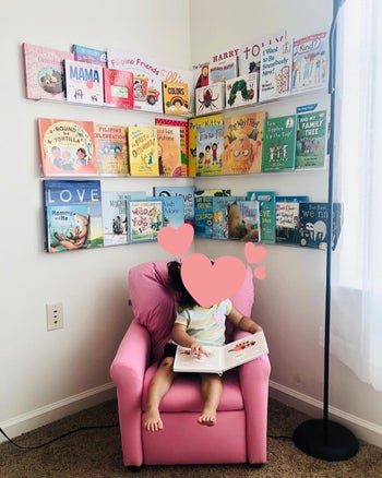 Reviewer's photo showing their child's books displayed on the invisible floating shelves attached to the wall