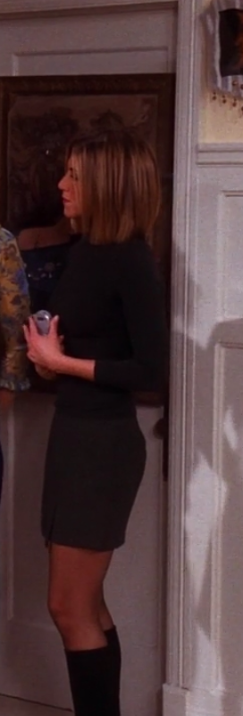 Rachel wearing boots, tights, a mini skirt, and a long-sleeve turtle neck