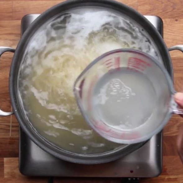 Preserving pasta water in a measuring cup.