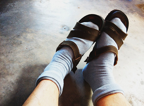 A person wearing socks and sandals together.