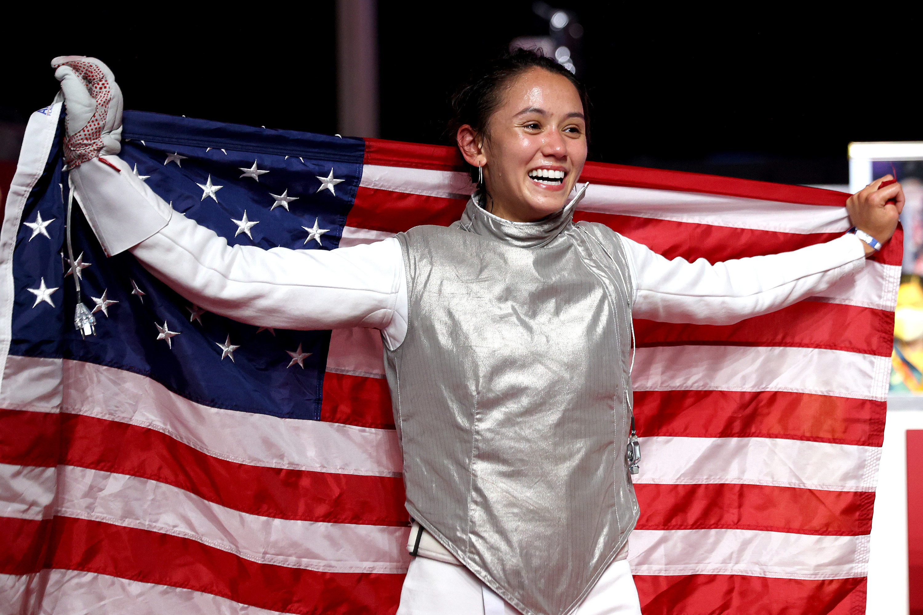 Lee holds up a U.S. flag as she poses for the cameras after her win