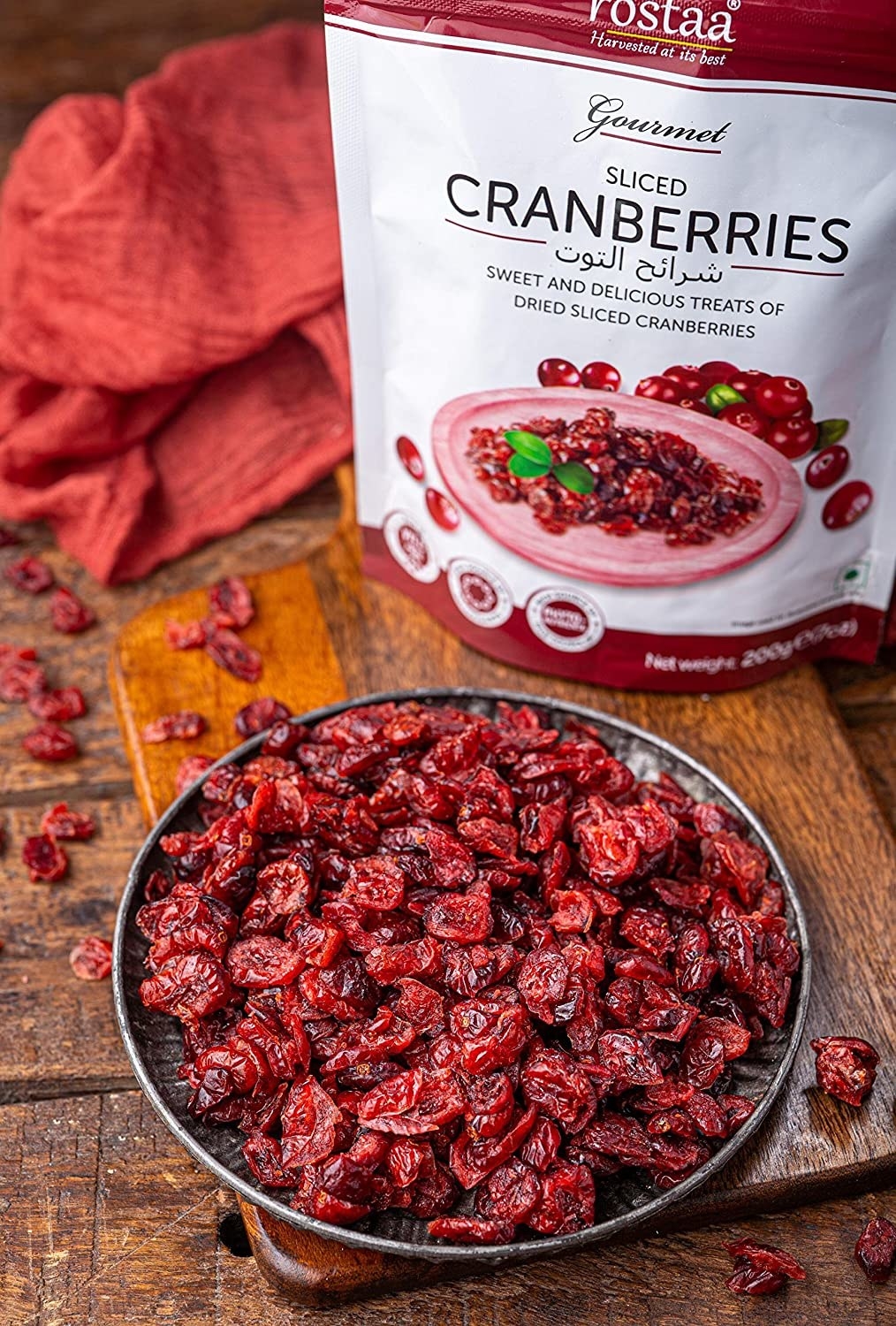 A bowl full of sliced cranberries kept beside their packet