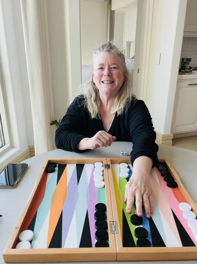 buzzfeeder's mom in front of a colorful, modern backgammon board