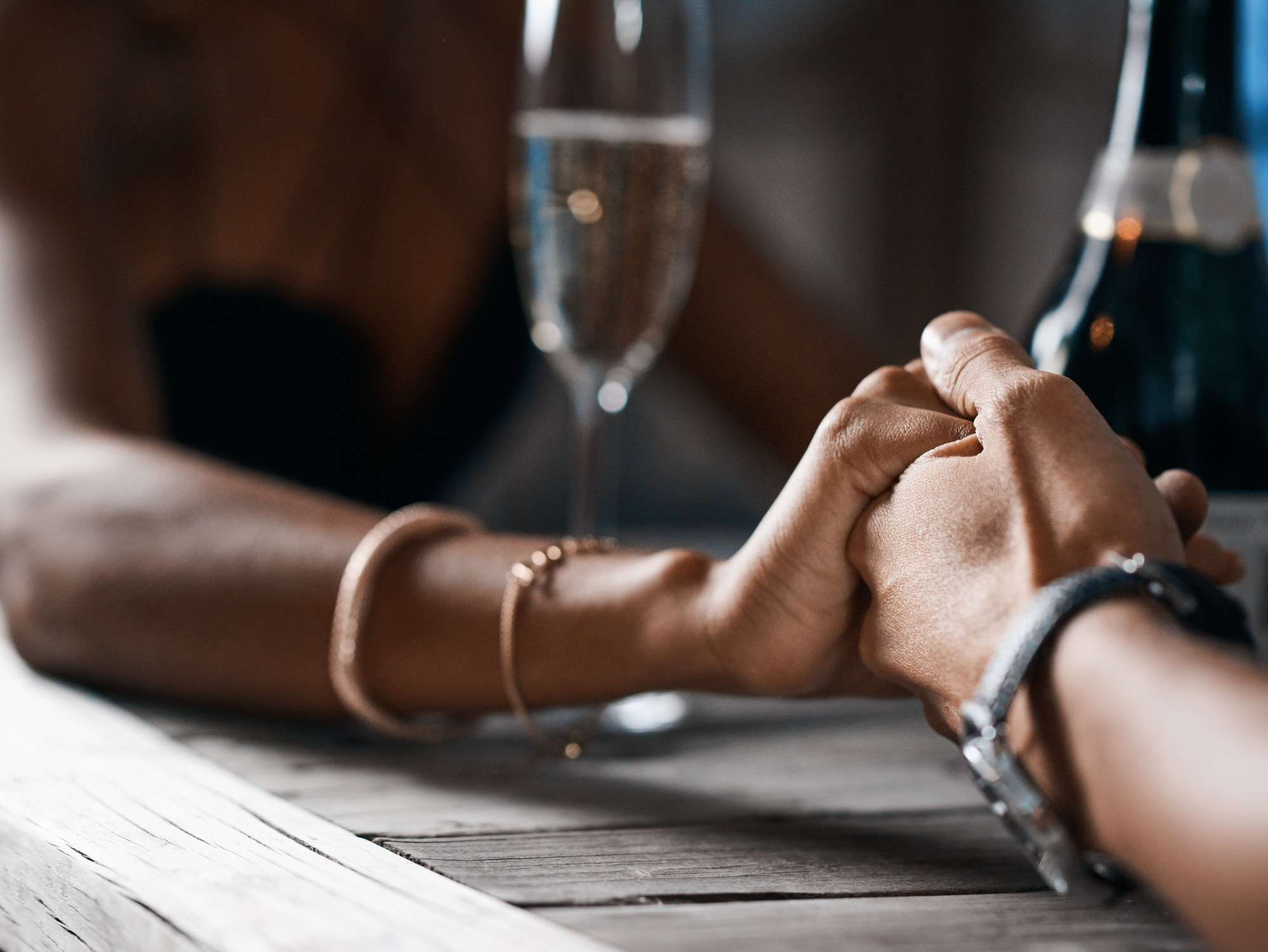A couple holds hands at dinner