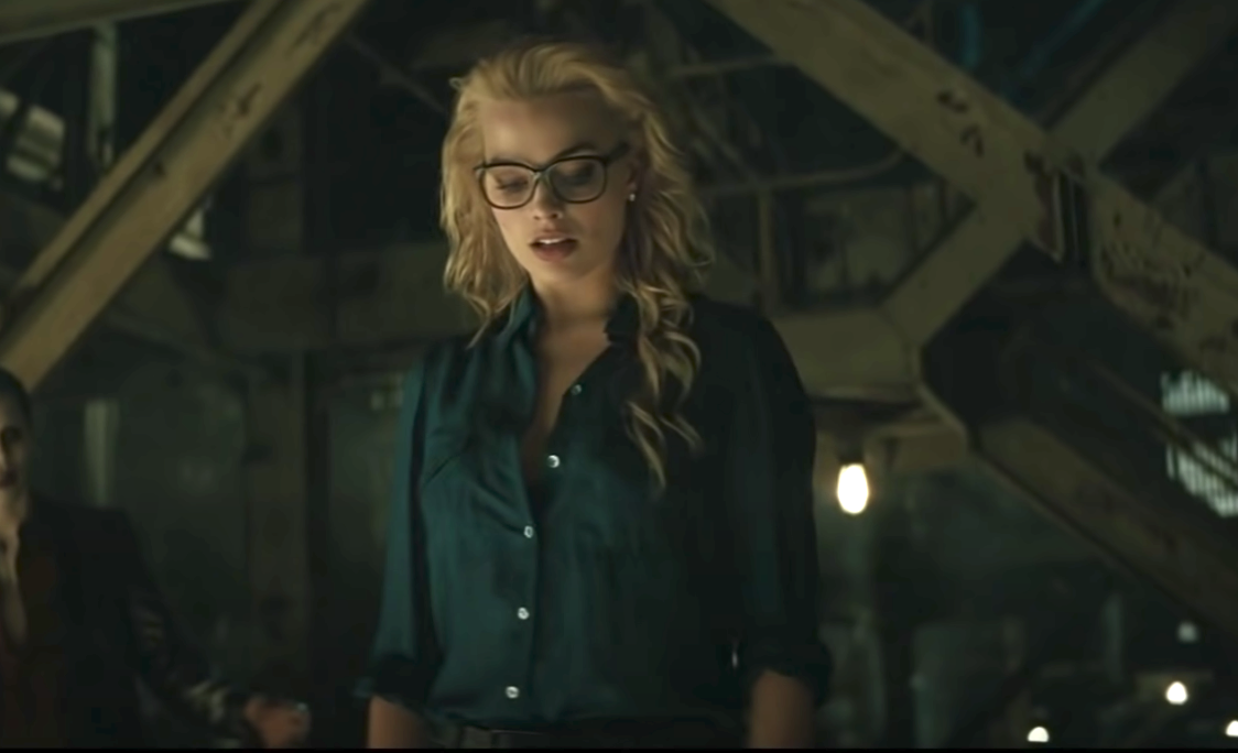 Harley in a plain rolled up long sleeve button up collared shirt and glasses