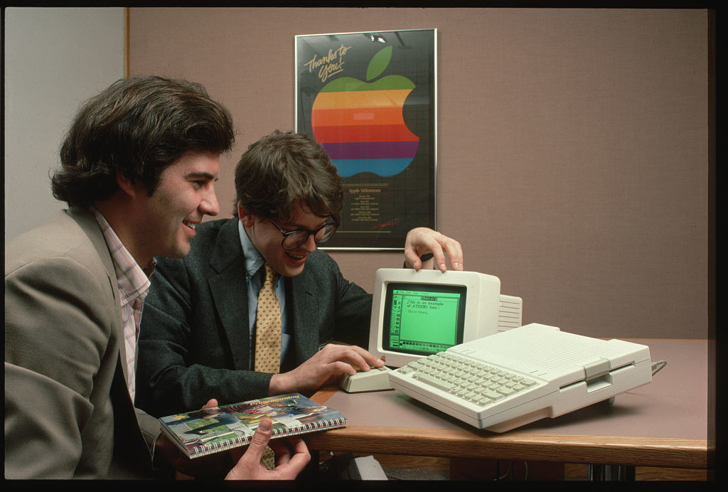 男人欣赏苹果IIc的电脑
