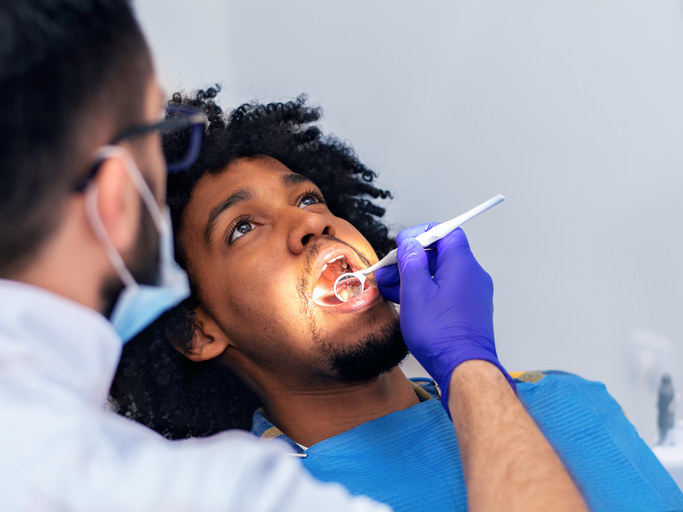 Dentist looking into a patient&#x27;s mouth with tools