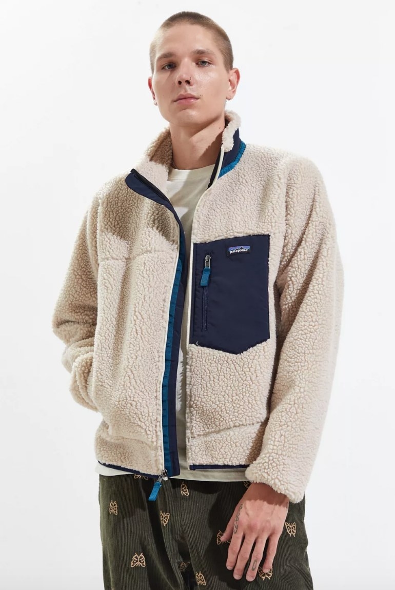 Model wearing cream colored fleece jacket with navy blue pocket and detailing