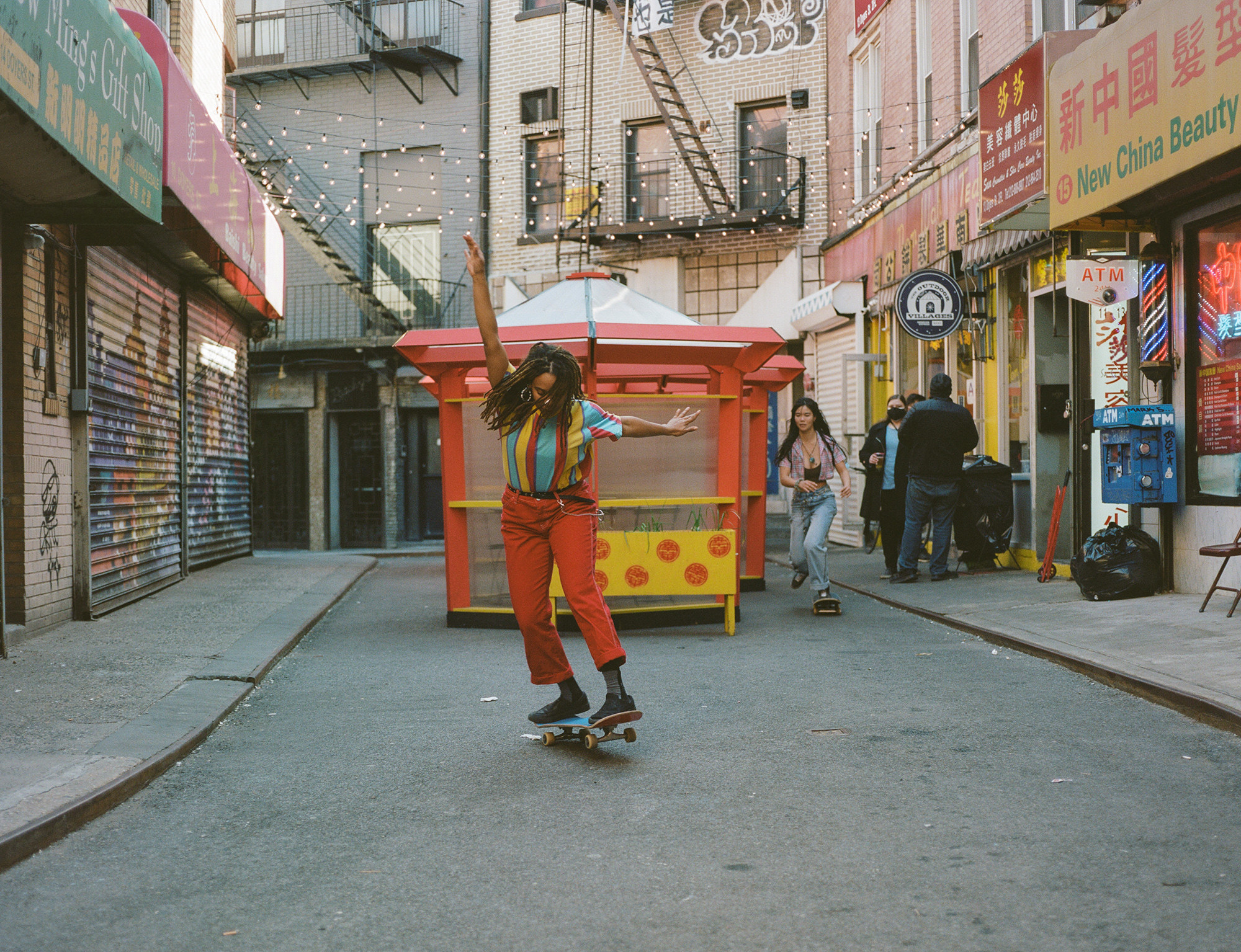 A woman doing a trick on a skateboard on the street