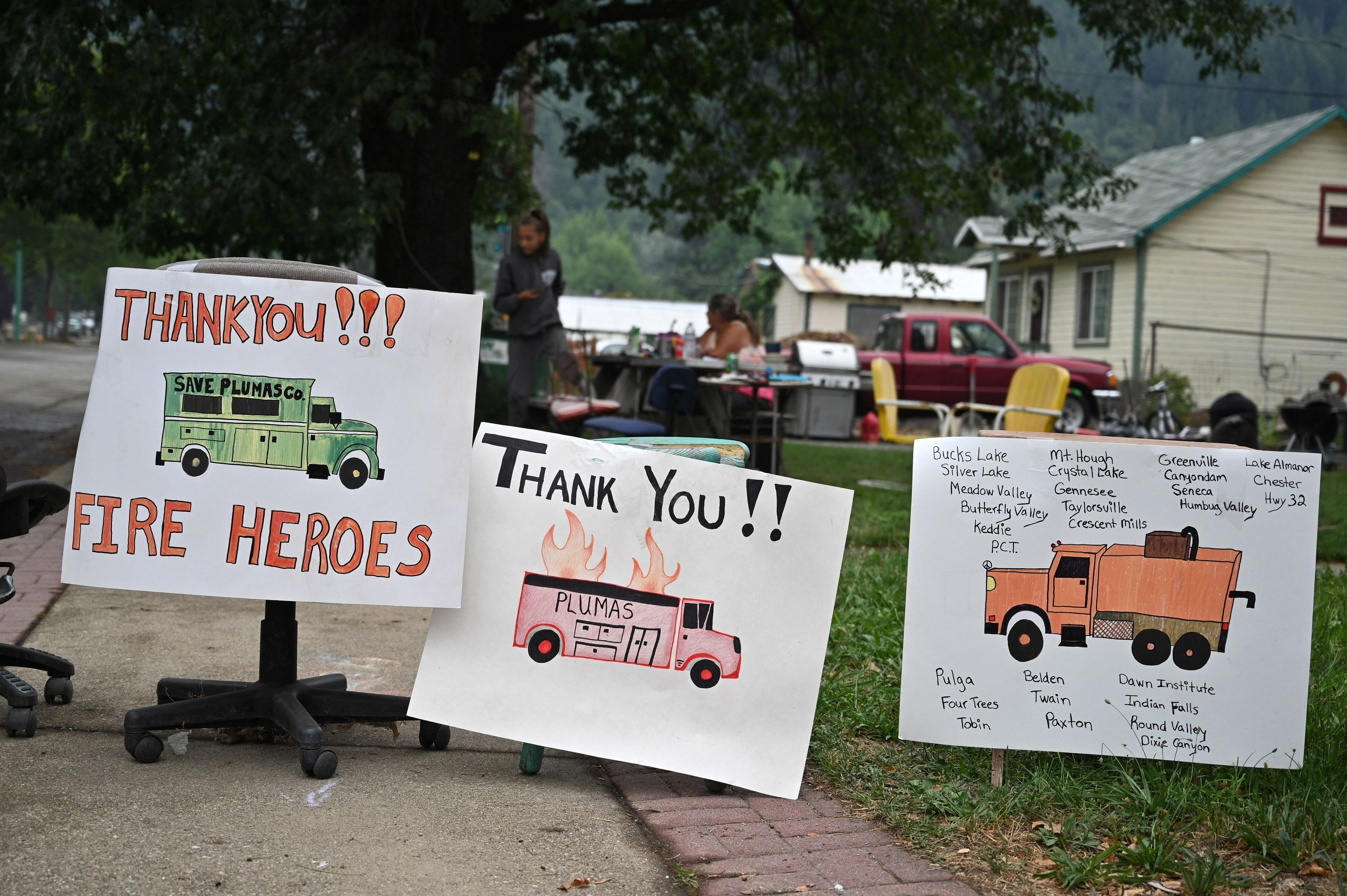 Hand-drawn signs read &quot;Thank you fire heroes&quot;