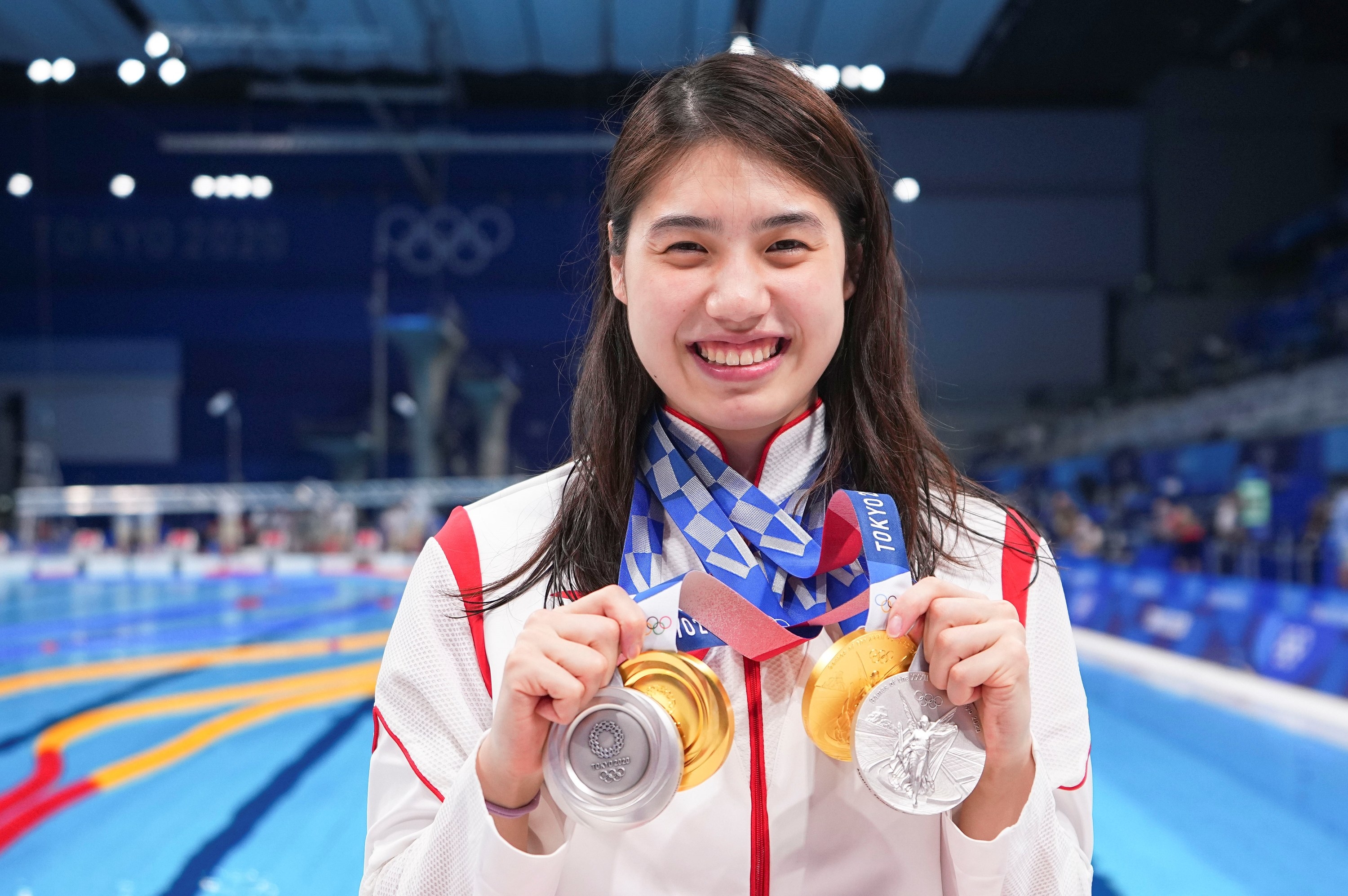Zhang Yufei smiles as she poses with four medals around her neck
