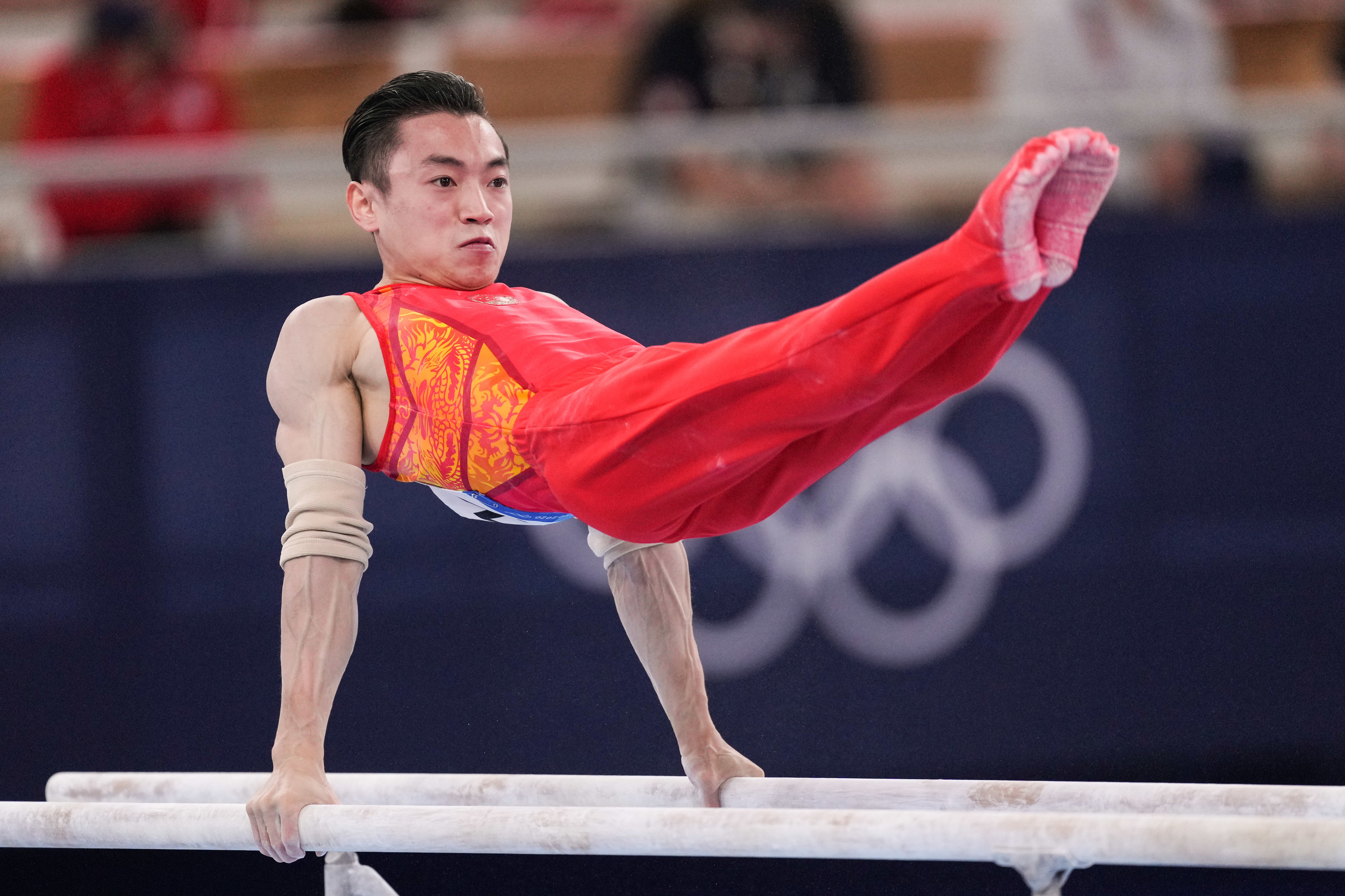 Zou Jingyuan lifting himself on the parallel bars