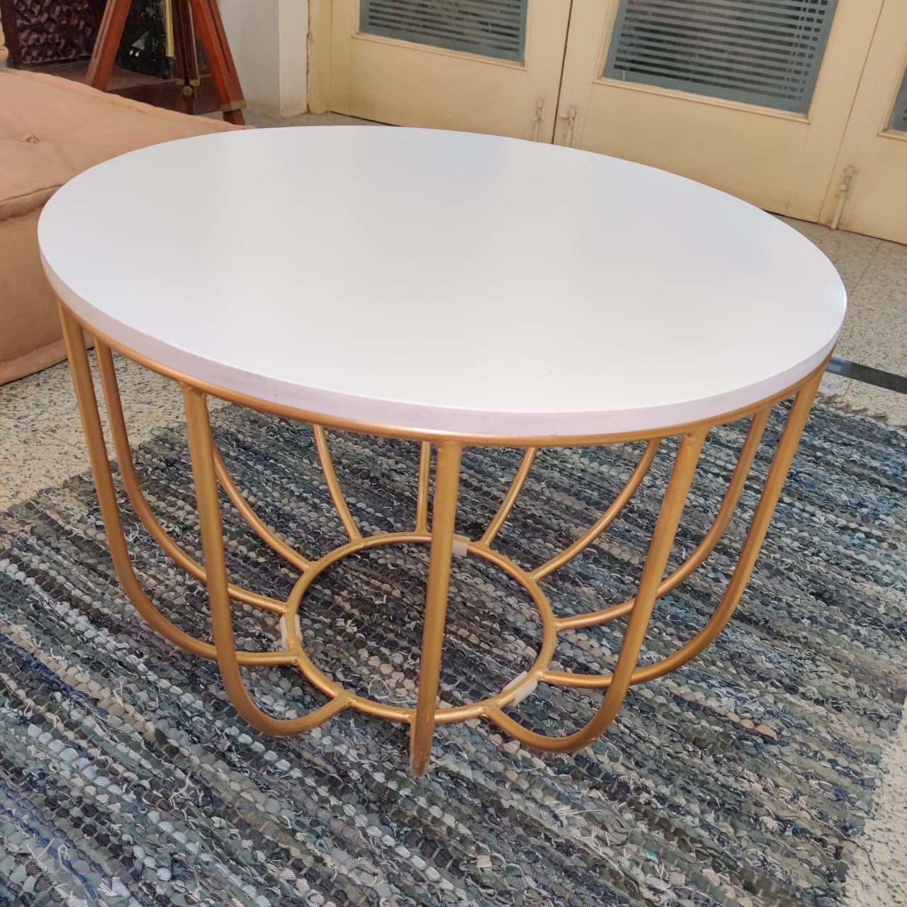A coffee table with a circular top and curved legs