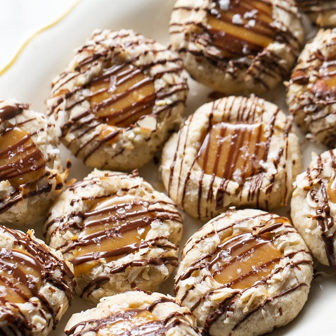 Coconut flake cookies filled with caramel and drizzled with chocolate sauce