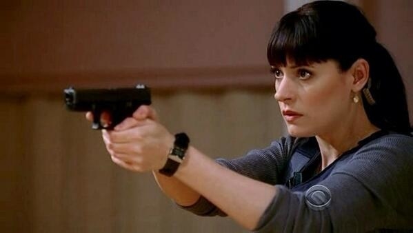 Emily Prentiss holds a gun, her hair is back in a ponytail 