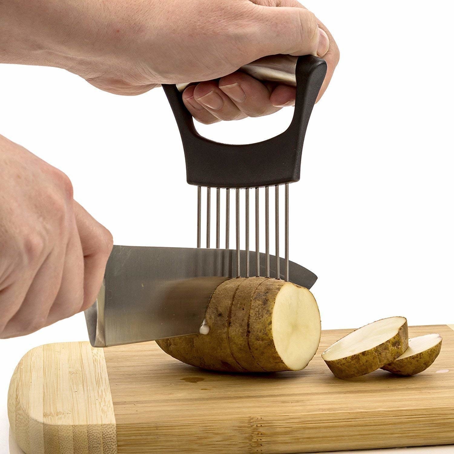 A person using the gadget to hold a potato while its being cut