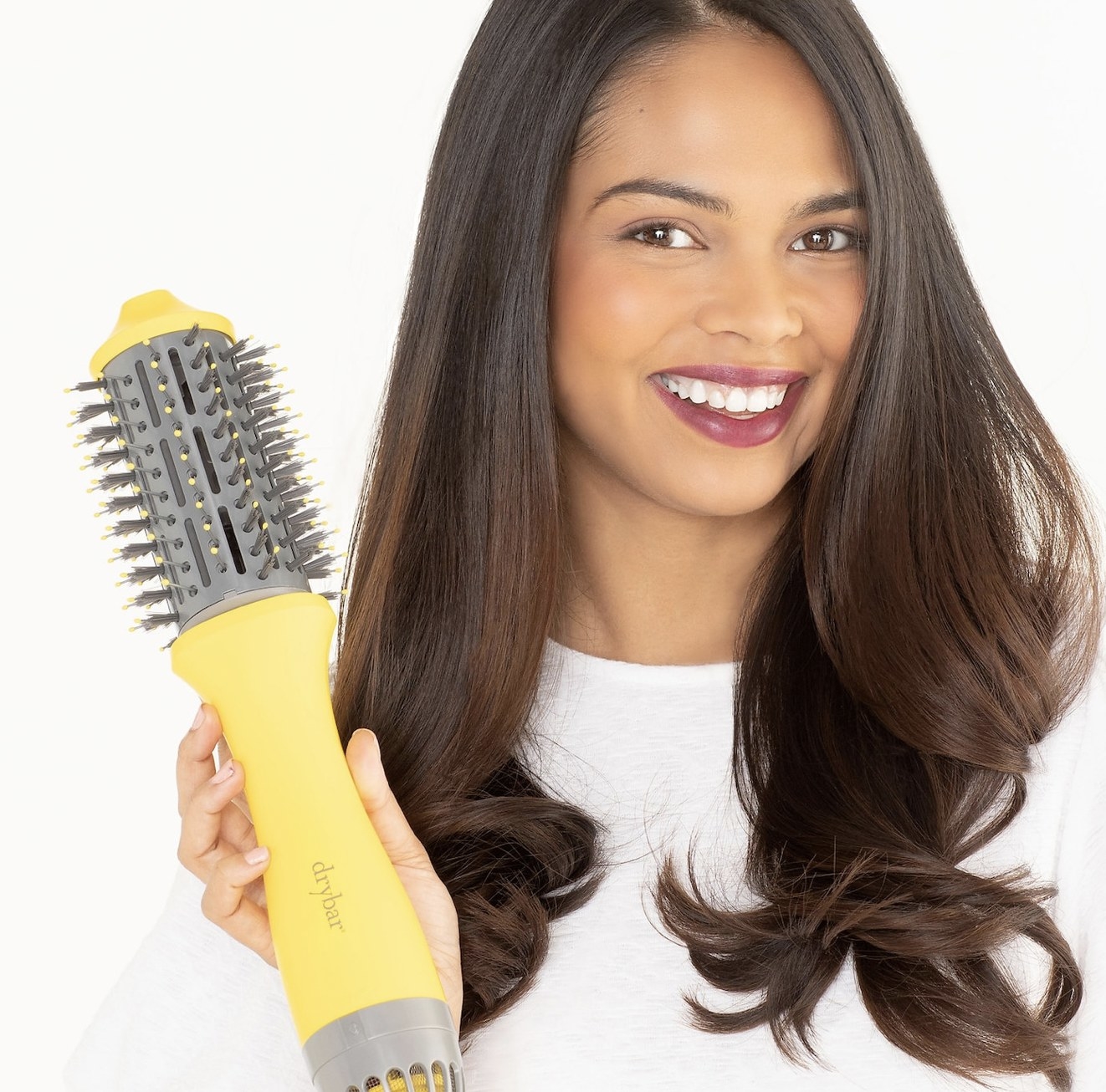 A woman holding a blow dryer brush