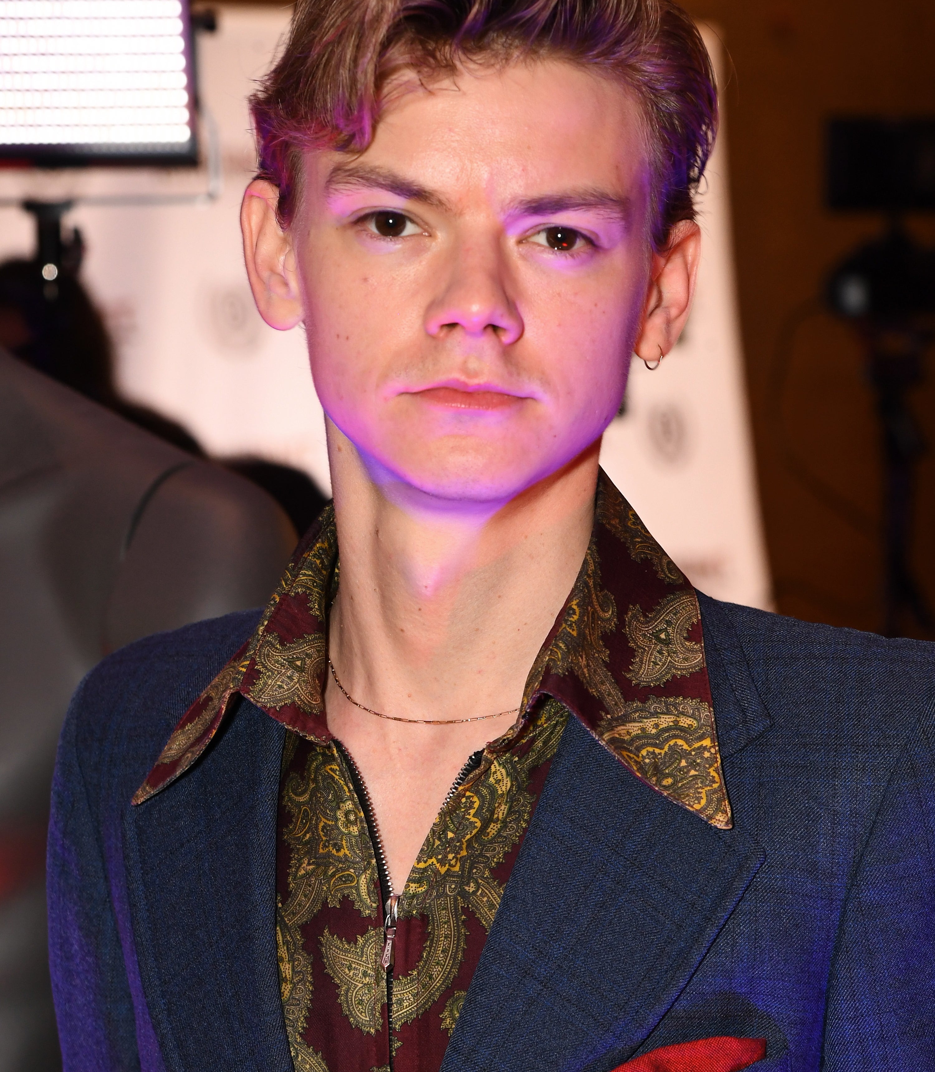 Thomas Brodie-Sangster wears a navy suit and minimalist jewelry at the 28th Raindance Film Festival