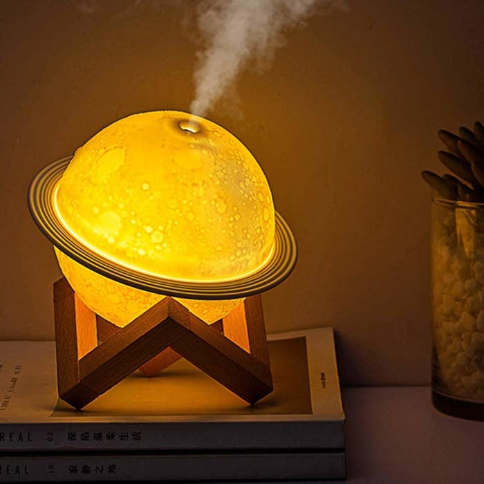 Moon shaped diffuser lamp kept on top of books on desk