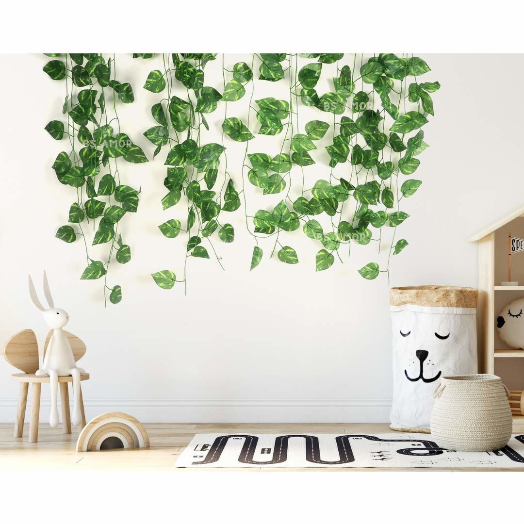 Artificial money plant vines hung up on the wall of a kid&#x27;s room