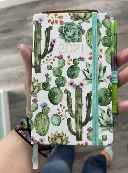 the pocket planner with watercolor cacti pattern and a pen in the pen holder