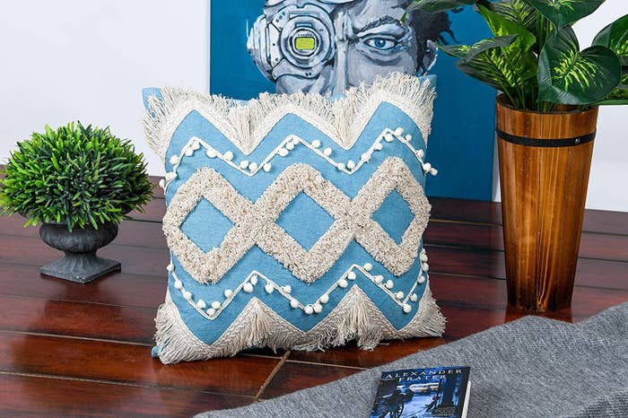 A  blue and white shaggy cushion kept on a wooden surface