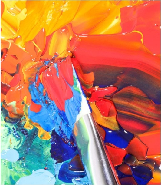 Foto de un pincel con varios colores de pintura acrílica