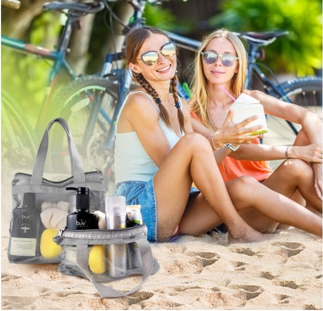 Foto de dos chicas en la playa con dos bolsas de malla gris a su costado.