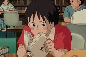 a boy from a studio ghibli movie reading a book