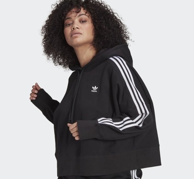 a person wearing the adidas hoodie with stripes down the sleeve