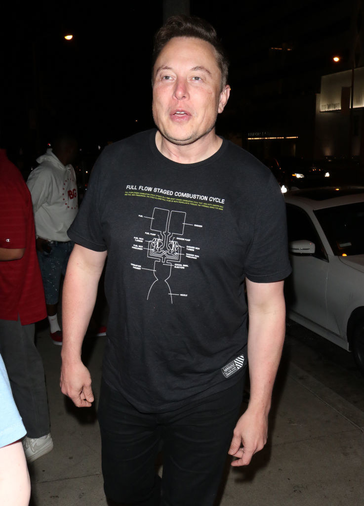 Elon Musk on the street in a dark T-shirt with &quot;Full Flow Staged Combustion Cycle&quot; at the top and a graphic with text below