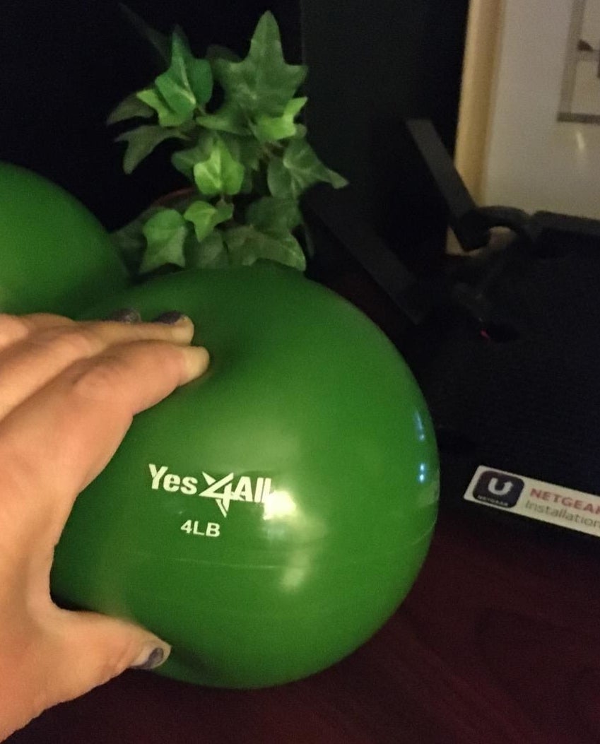 A reviewer squeezes a four-pound green ball