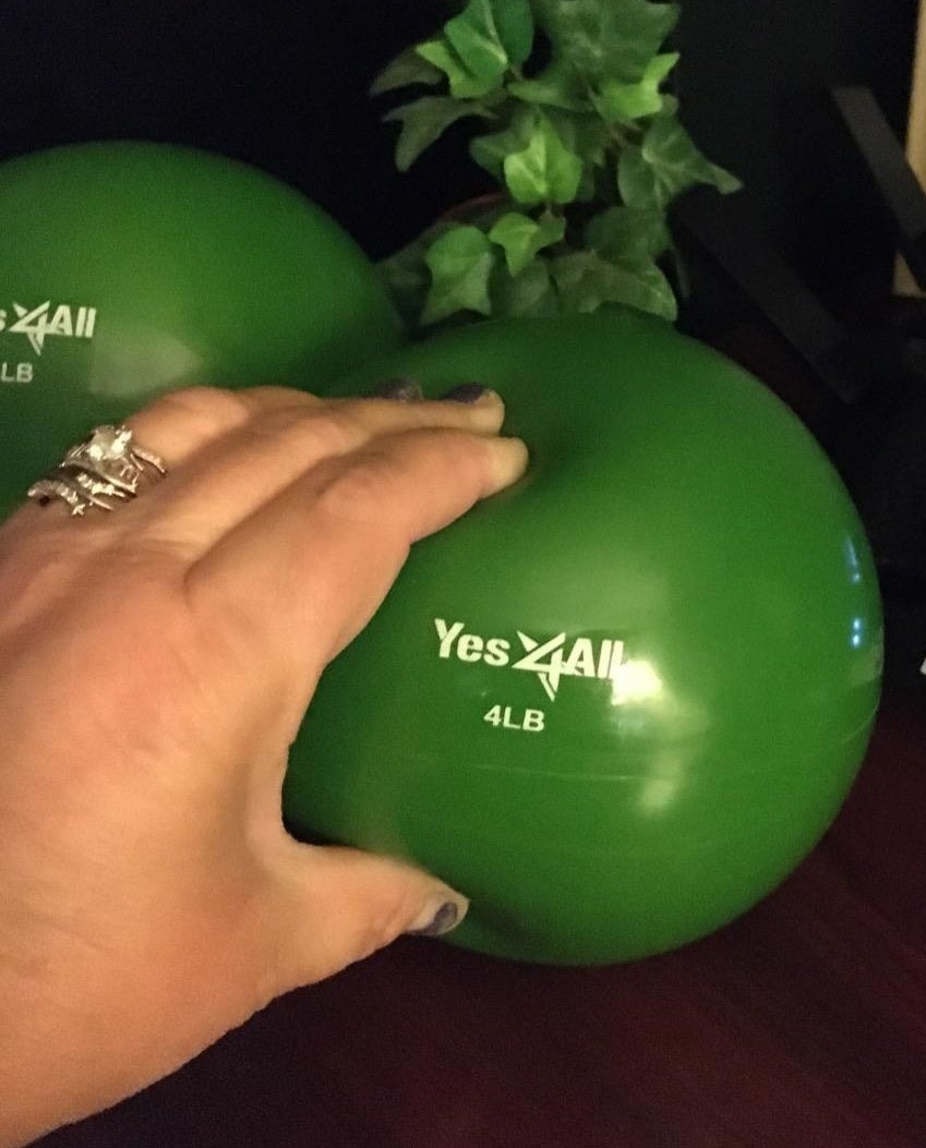 A reviewer squeezes a four-pound green ball