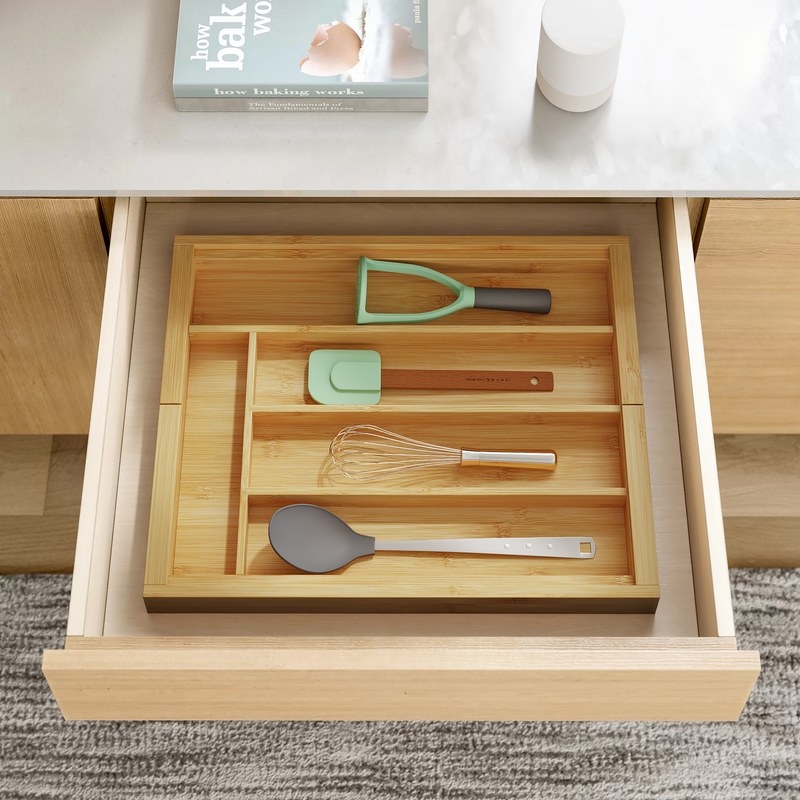 Bamboo organizer in drawer holding cooking utensils