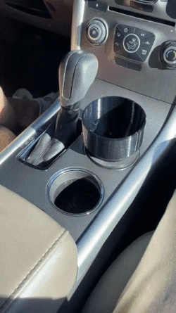 gif of a water bottle not fitting in the normal cup holder but then fitting perfectly in the adaptor that&#x27;s in the cup holder above it