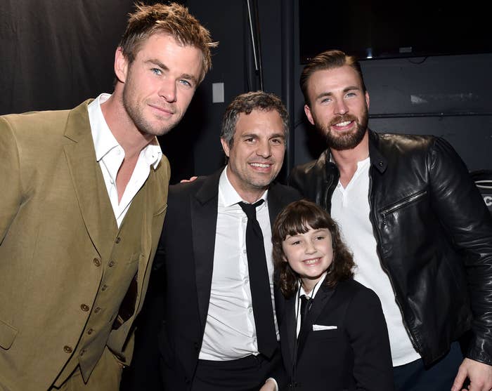 Mark poses with Bella, then a little girl, while standing next to Chris Hemsworth and Chris Evans