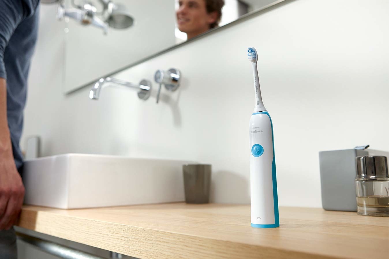 An image of an electric toothbrush kept on bathroom countertop