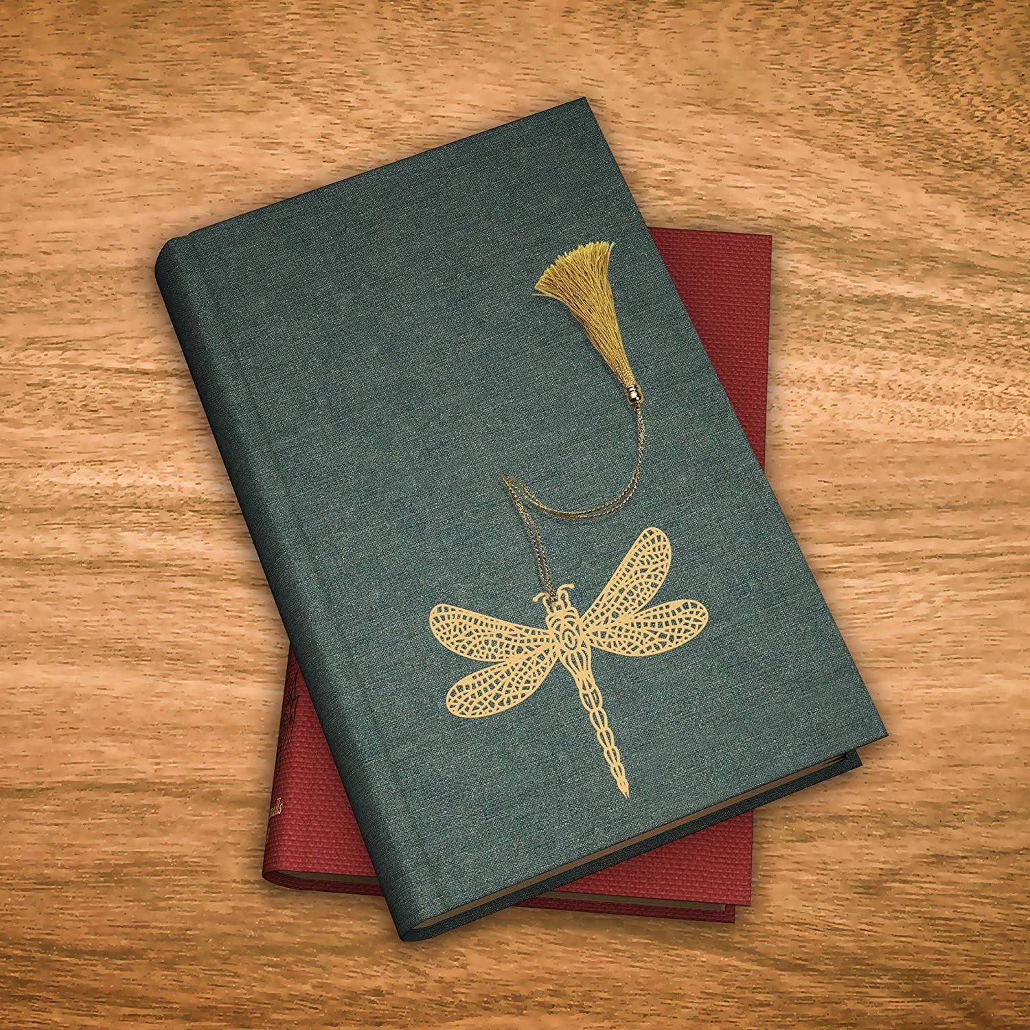A gold filigree dragonfly bookmark on a book