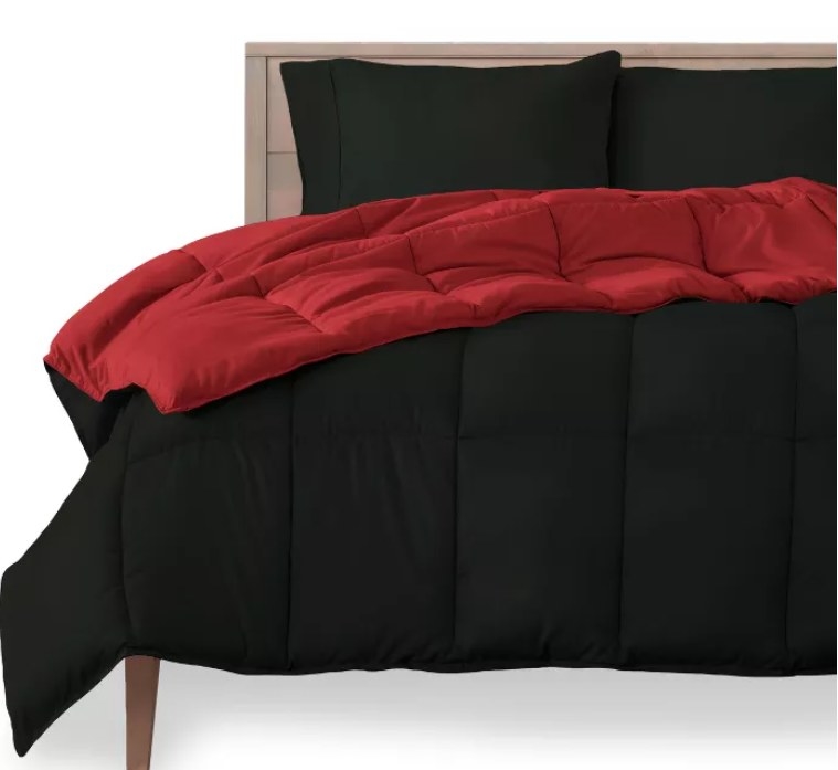 A black and red reversible comforter on a bed