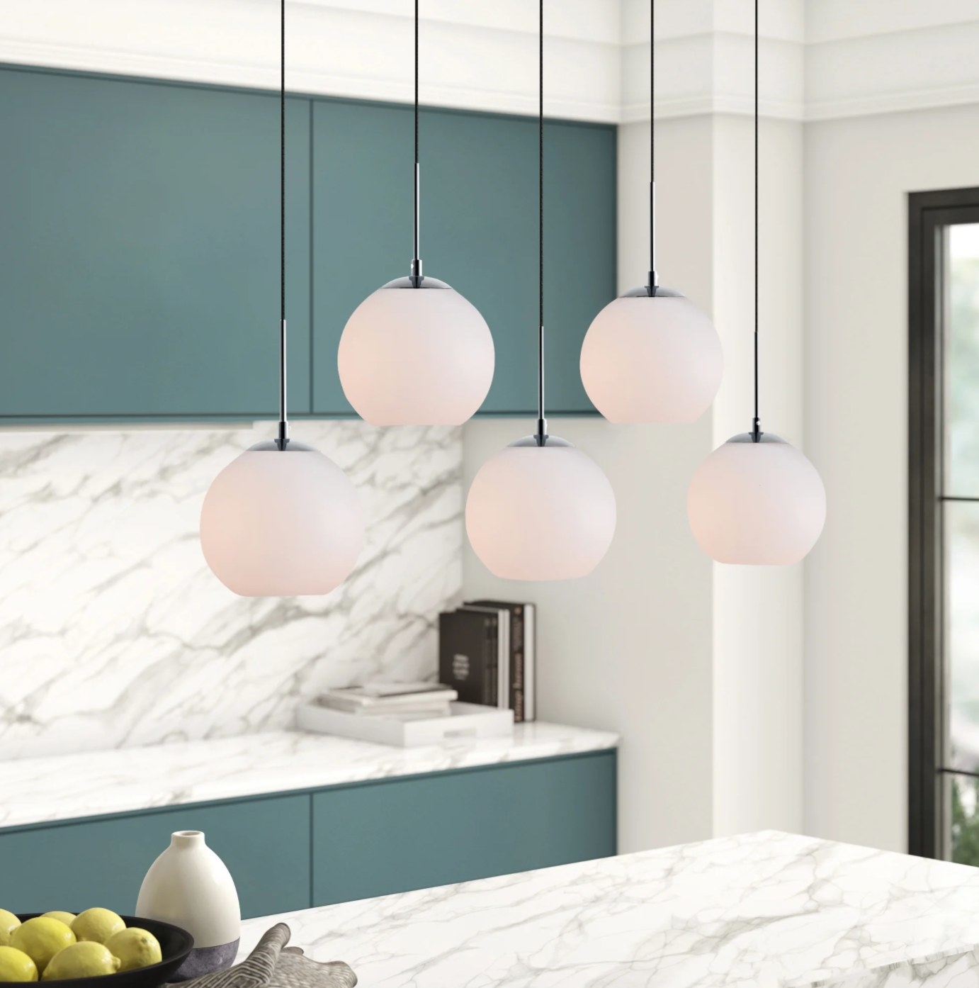 the globe light fixtures with frosted white outsides hanging above a marble countertop