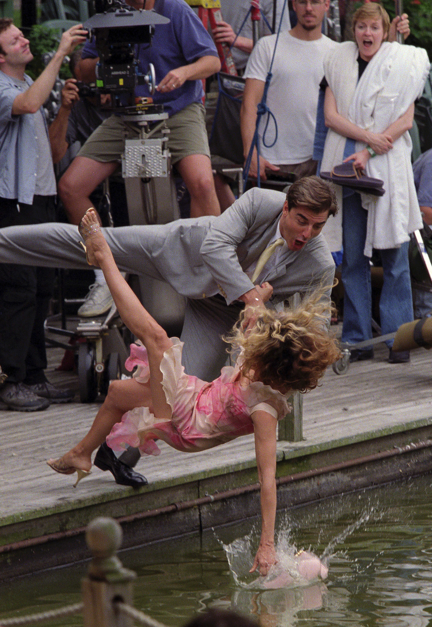 A behind-the-scenes shot of SATC filmmakers shooting Sarah Jessica Parker and Chris Noth falling into the lake at Central Park
