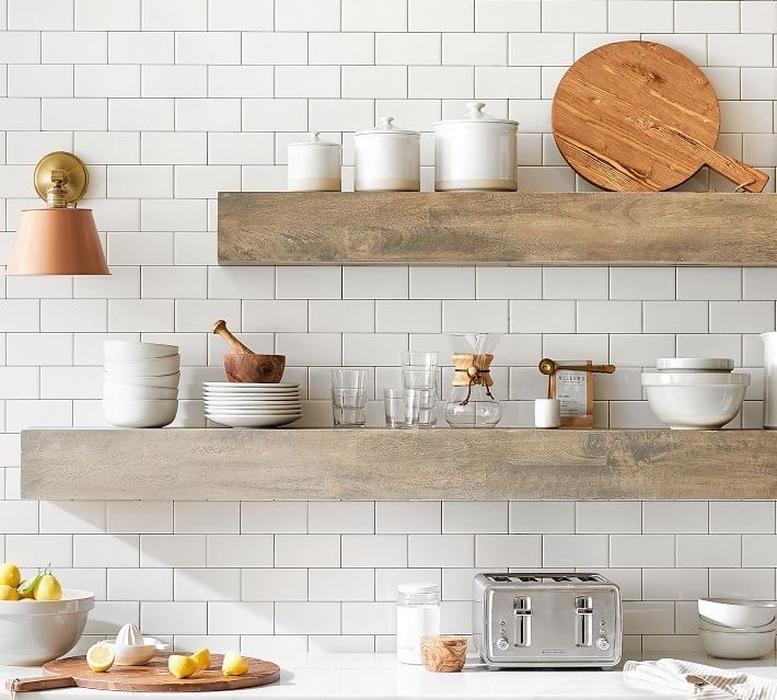 two floating shelves in a kitchen in different sizes