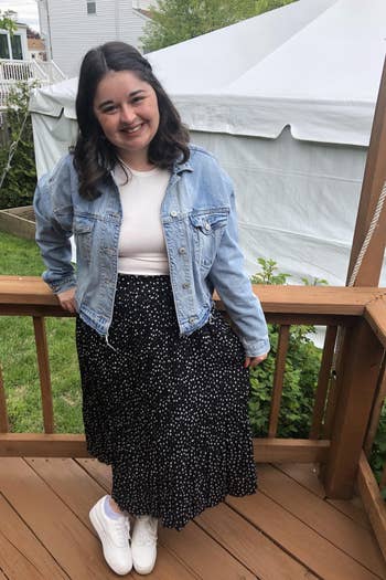 Heather wearing black with white dots skirt with a jean jacket and sneakers