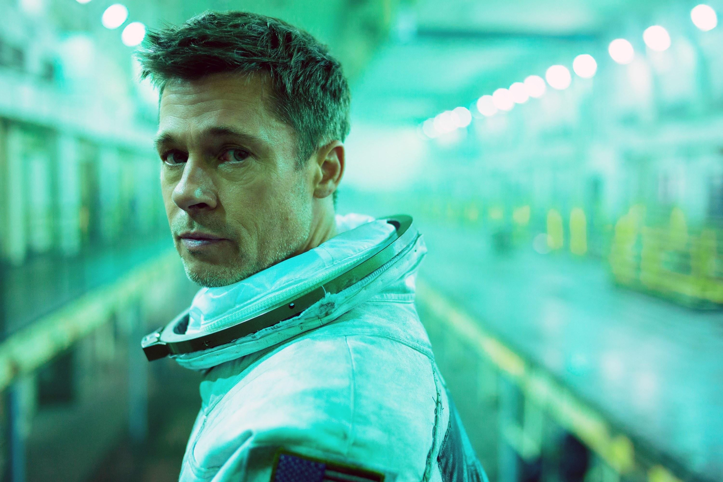 Brad Pitt stands in an astronaut uniform