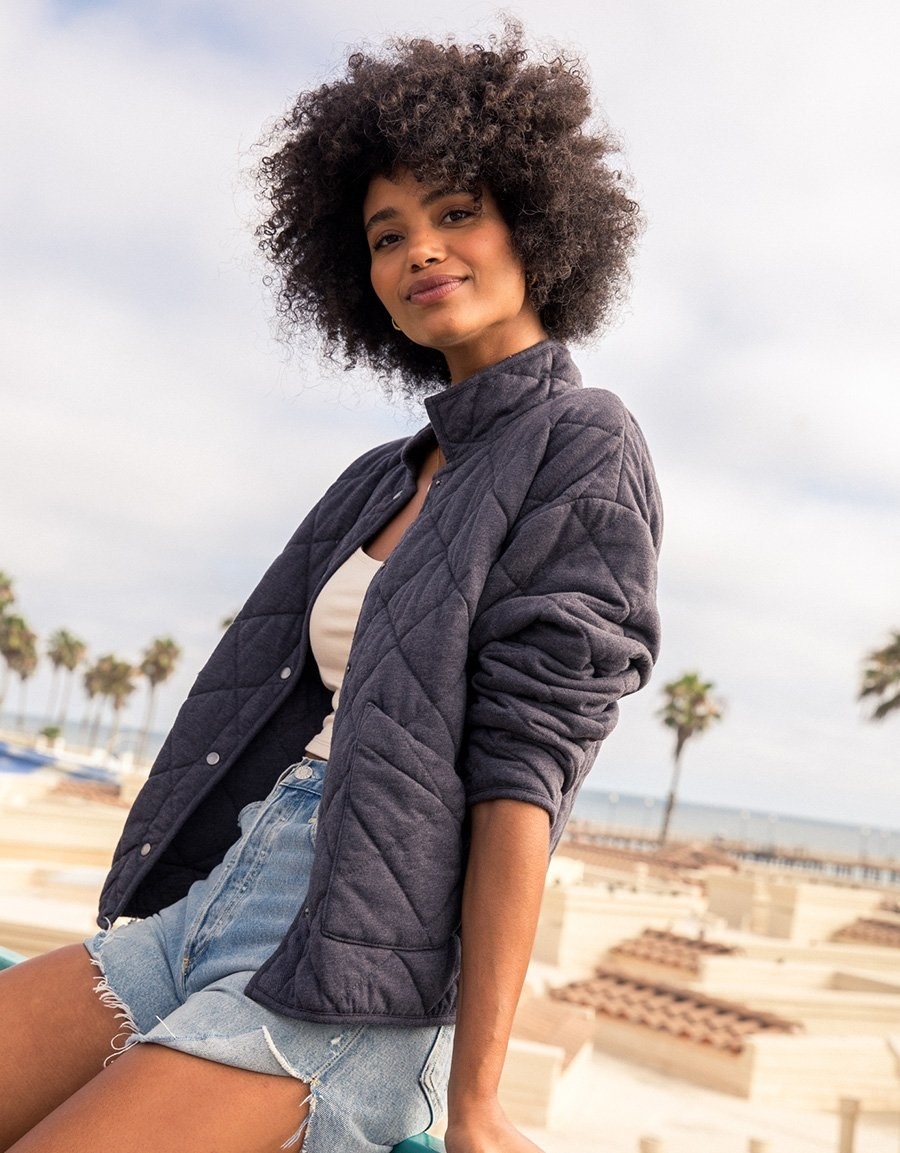 model wearing jacket with shorts and sleeves rolled up
