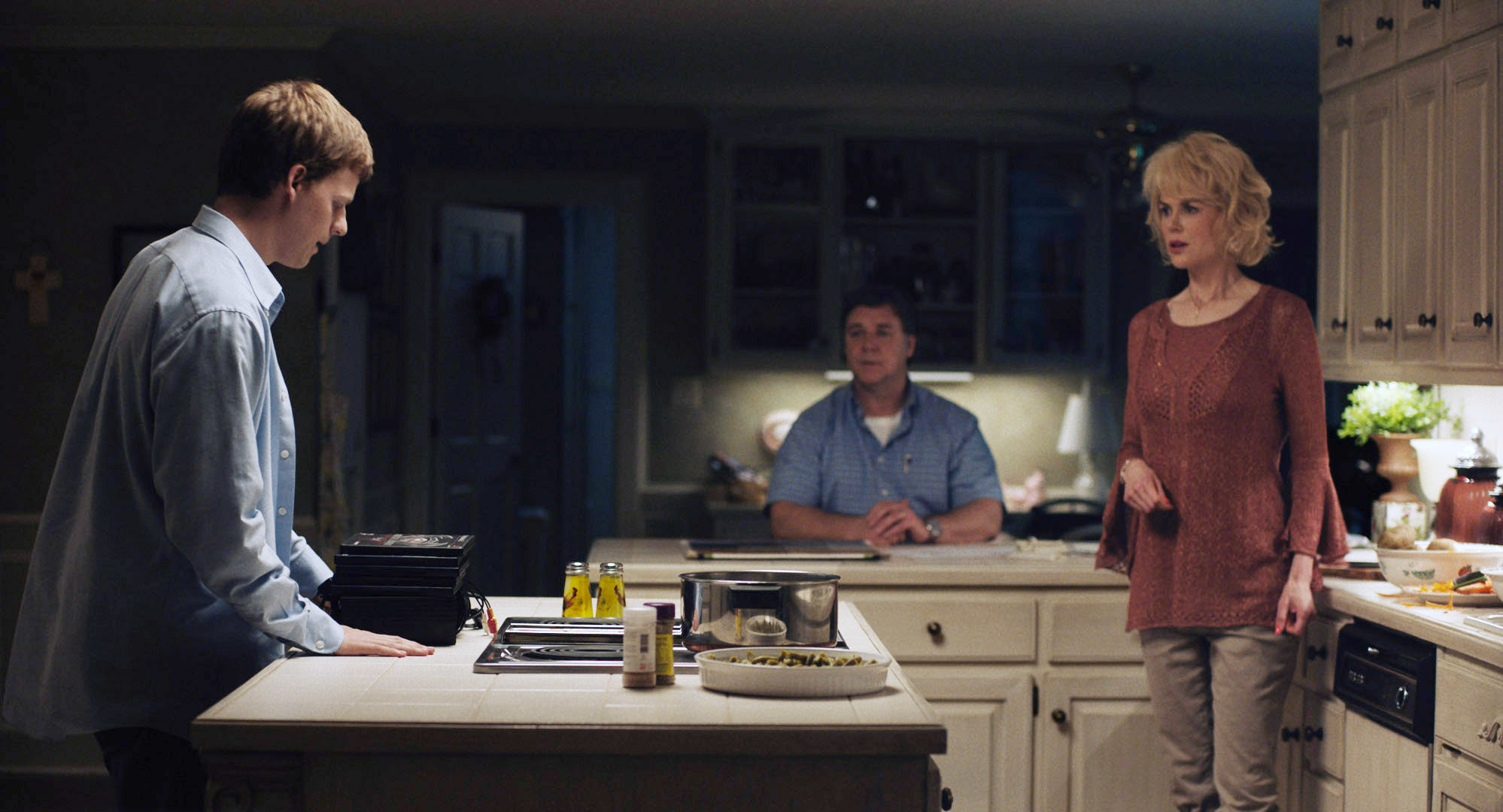 Lucas Hedges, Russell Crowe, and Nicole Kidman have a conversation in a kitchen at night